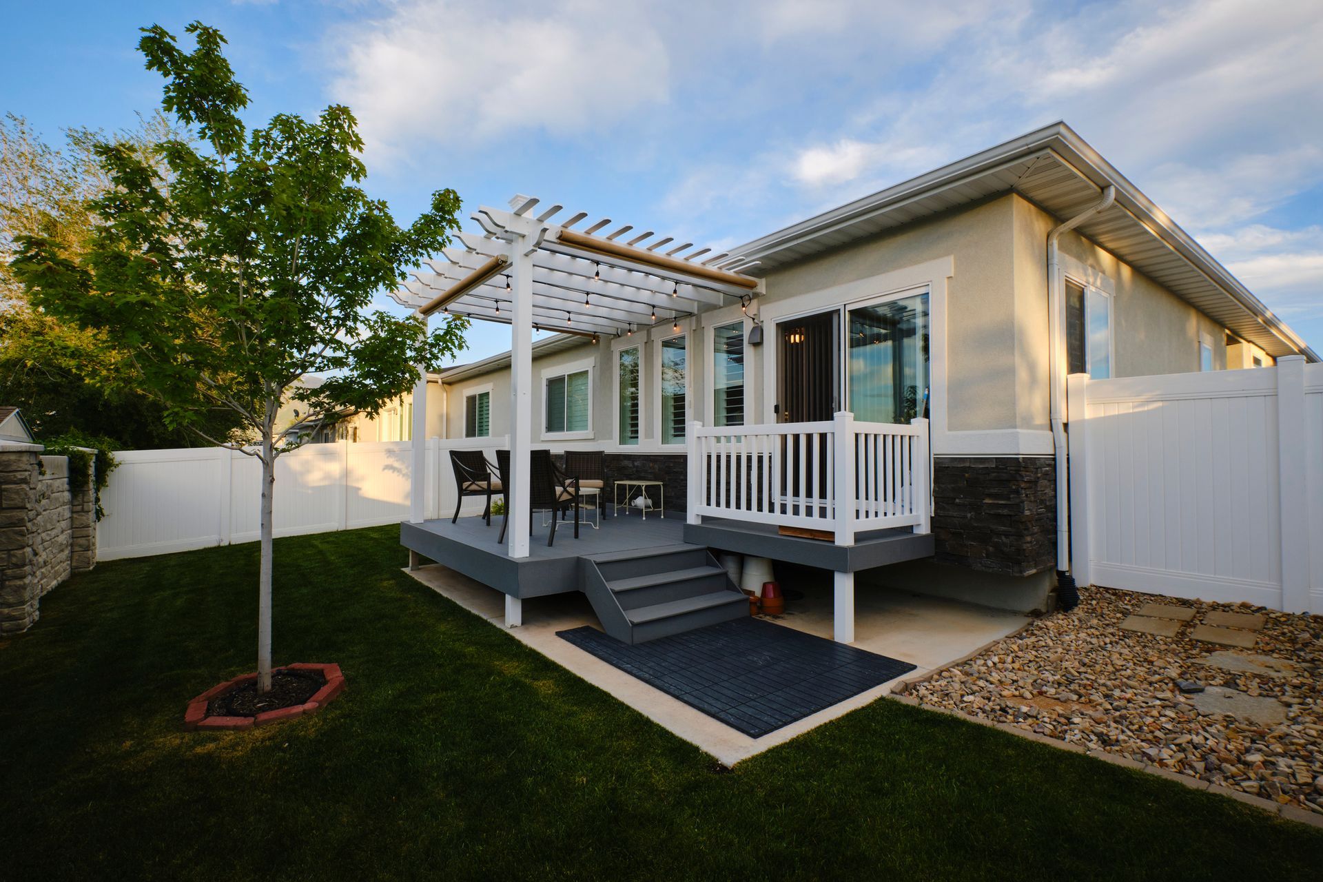 A house with a deck and a pergola in the backyard
