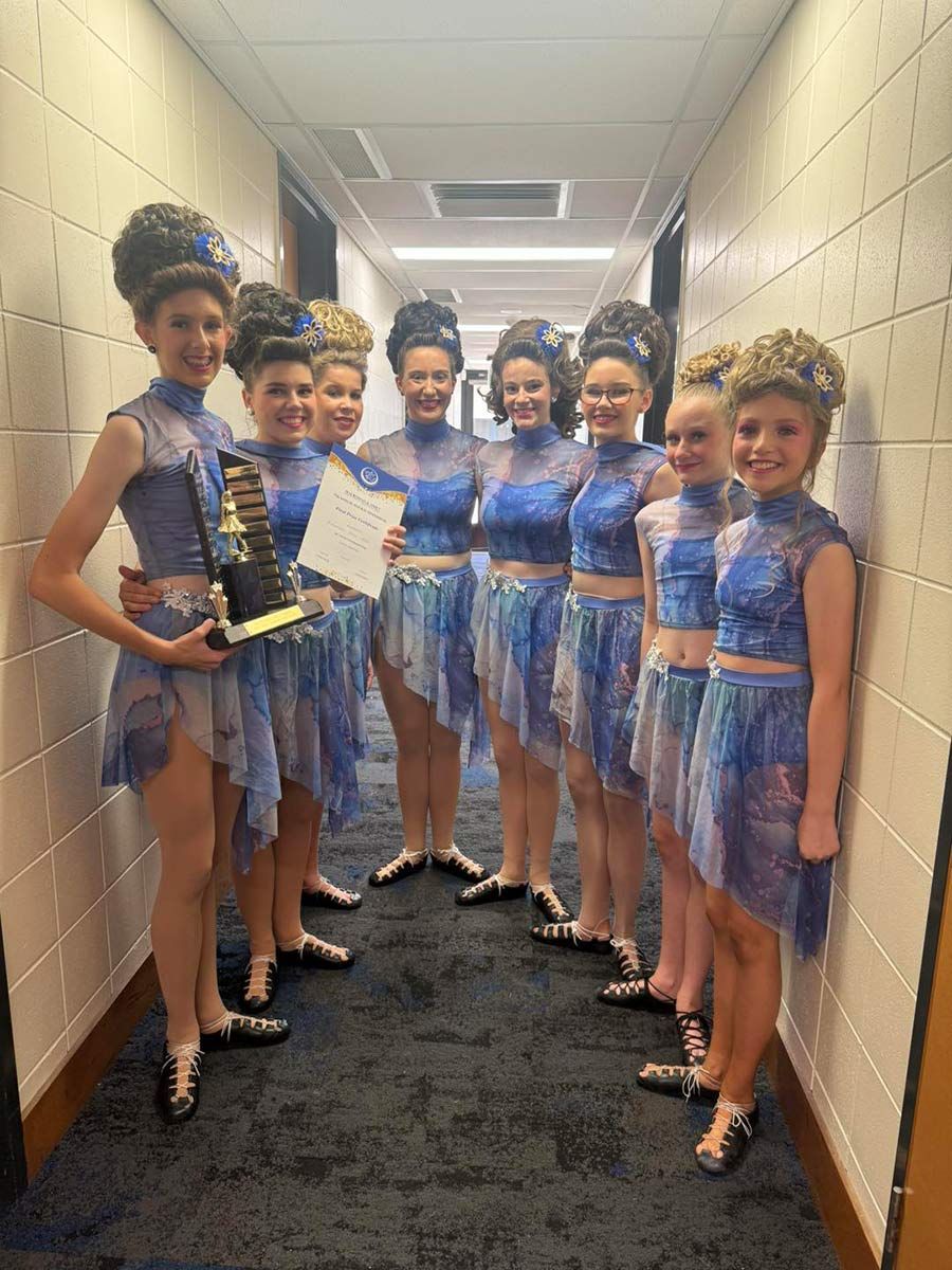 A Group Of Young Girls Are Standing In A Hallway Holding A Trophy — International Dance Affair In North Mackay, QLD