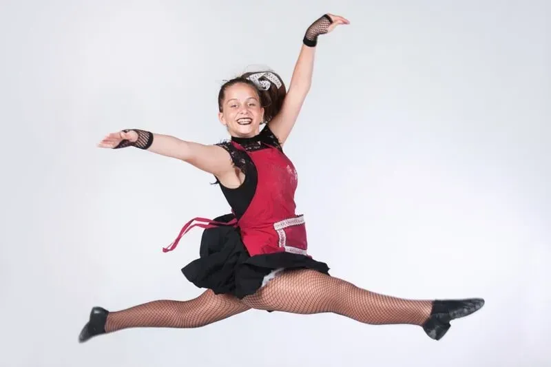 A Young Girl In A Red And Black Dress Is Jumping In The Air — International Dance Affair In North Mackay, QLD