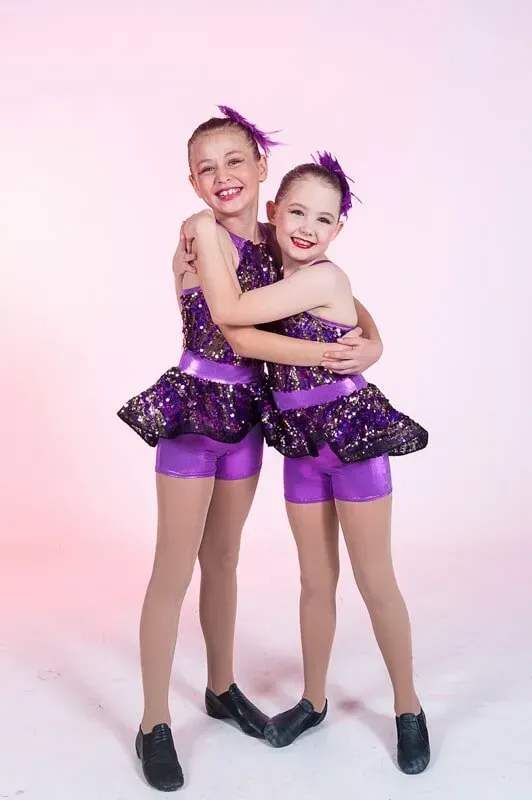 Two Young Girls In Purple Dance Costumes Are Hugging Each Other — International Dance Affair In North Mackay, QLD