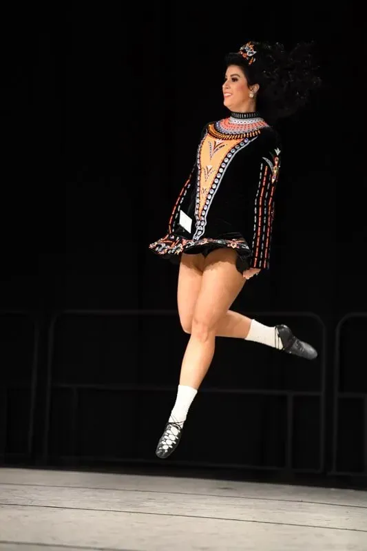 A Woman In A Black Dress Is Jumping In The Air — International Dance Affair In North Mackay, QLD