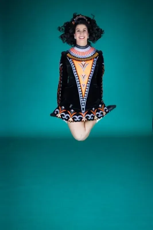 A Woman In A Black Dress Is Jumping In The Air — International Dance Affair In North Mackay, QLD