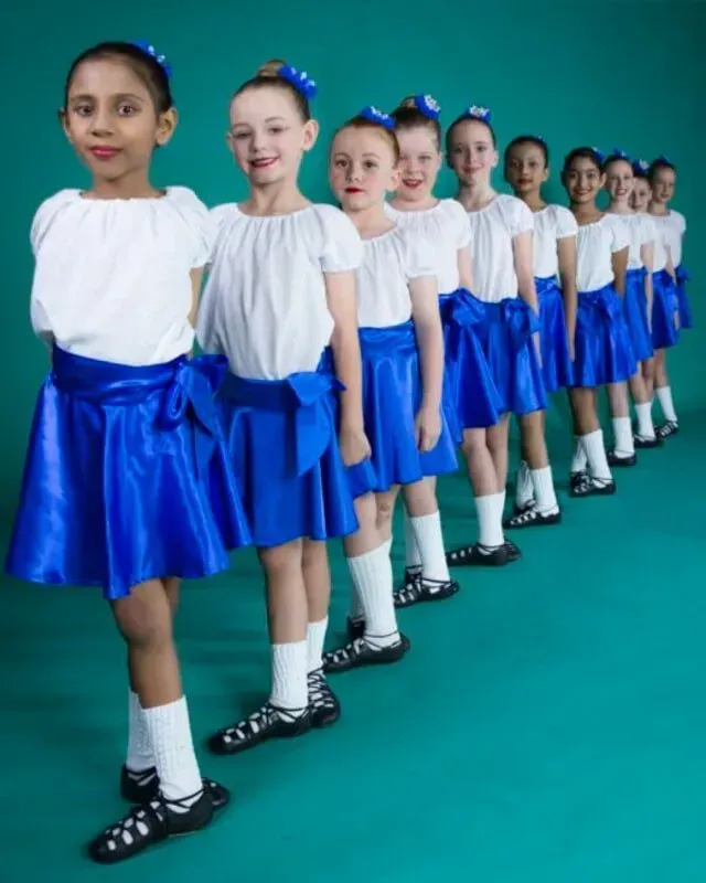 A Row Of Young Girls Wearing Blue Skirts And White Shirts — International Dance Affair In North Mackay, QLD