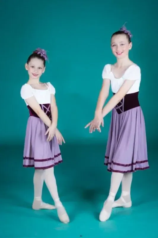 Two Young Girls In Purple Skirts Are Standing Next To Each Other — International Dance Affair In North Mackay, QLD