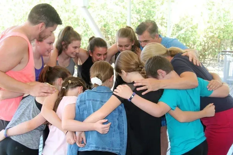 A Group Of People Are Hugging Each Other In A Circle — International Dance Affair In North Mackay, QLD