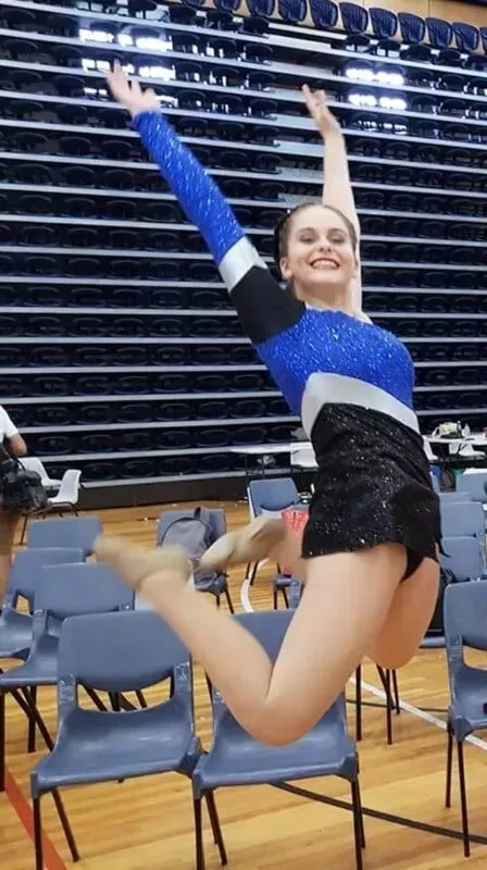 A Girl In A Blue And Black Leotard Is Jumping In The Air — International Dance Affair In North Mackay, QLD