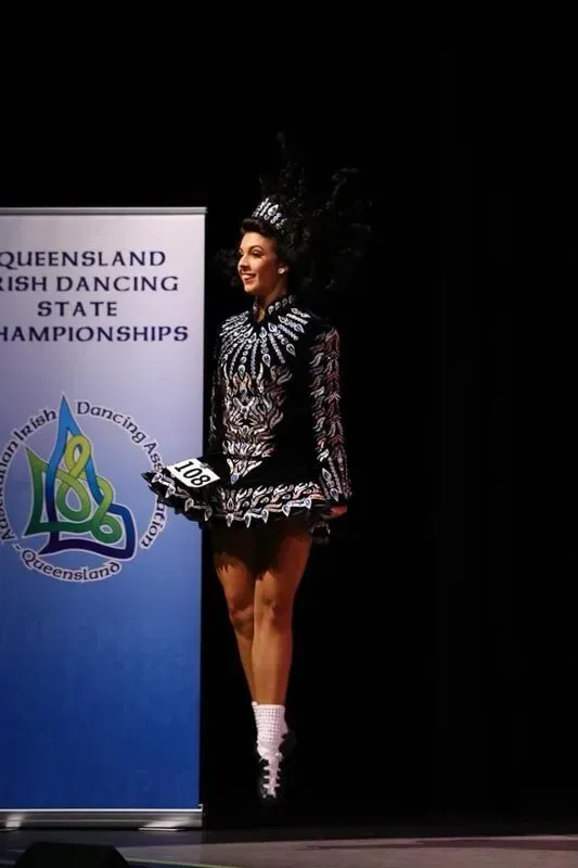 A Woman Is Standing In Front Of A Sign — International Dance Affair In North Mackay, QLD