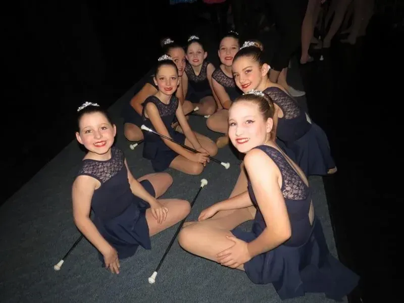 A Group Of Young Girls Are Sitting On The Floor With Their Wands — International Dance Affair In North Mackay, QLD