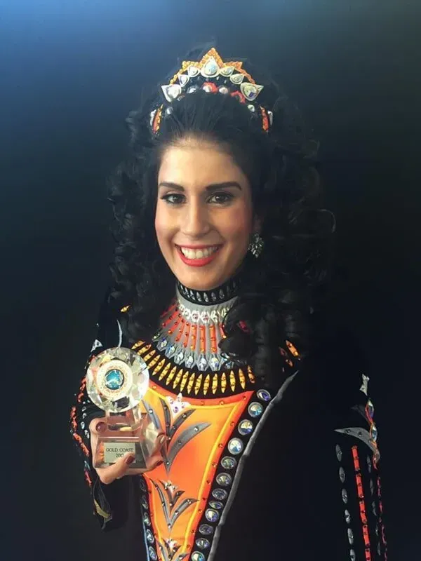 A Woman In A Costume Is Holding A Trophy And Smiling — International Dance Affair In North Mackay, QLD