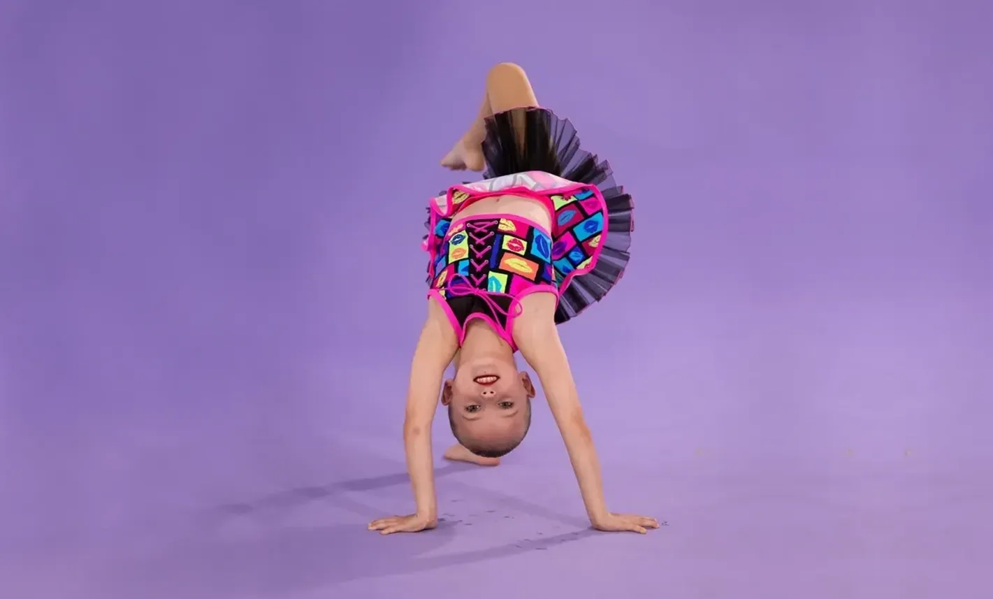 A Young Girl Is Doing A Handstand On A Purple Background — International Dance Affair In North Mackay, QLD