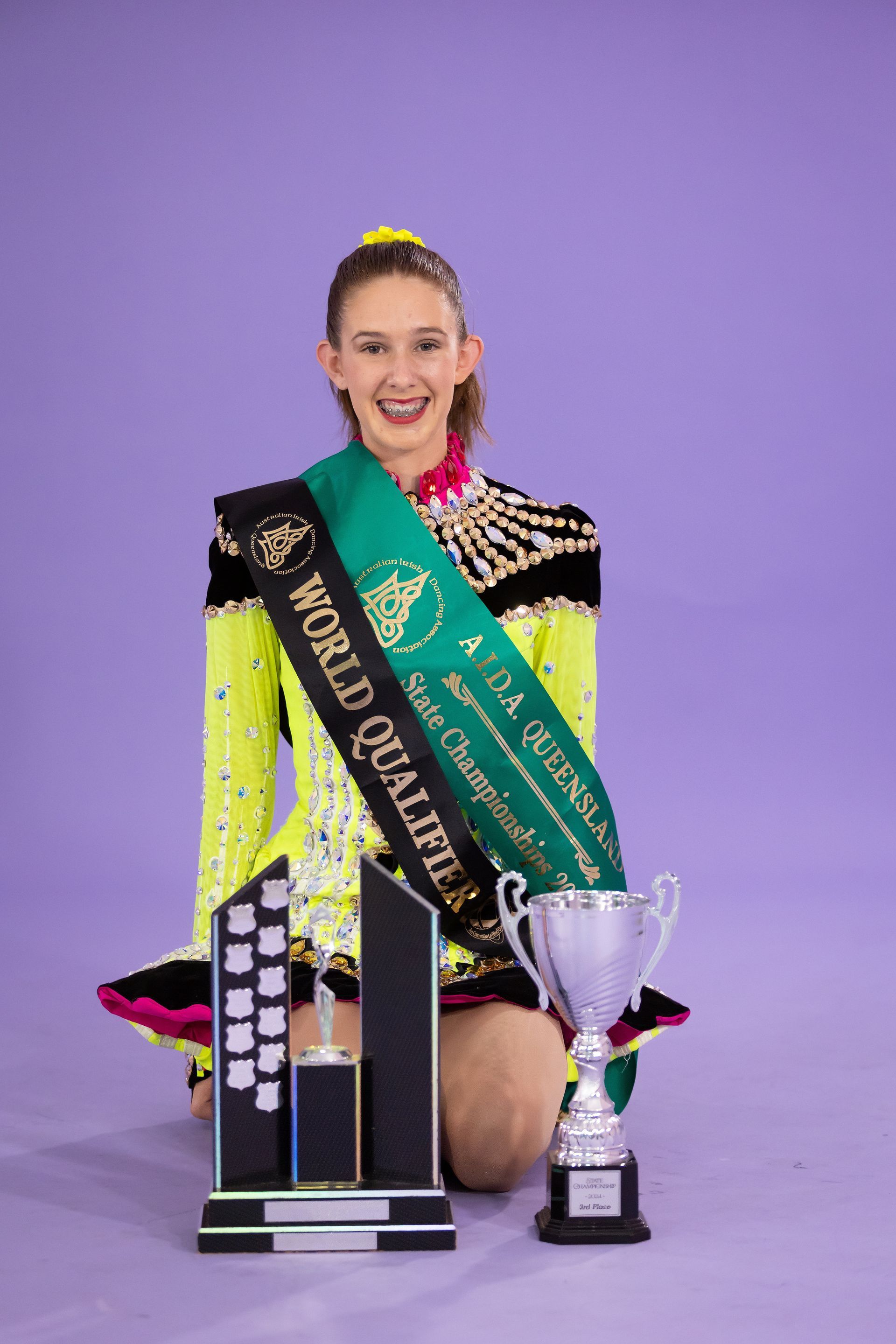 A Young Girl Is Kneeling Down Next To A Trophy And A Sash — International Dance Affair In North Mackay, QLD