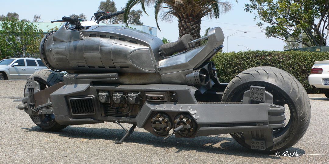 Priest Bike - Futuristic gray motorcycle parked outdoors, with large tires and a tank-like body.