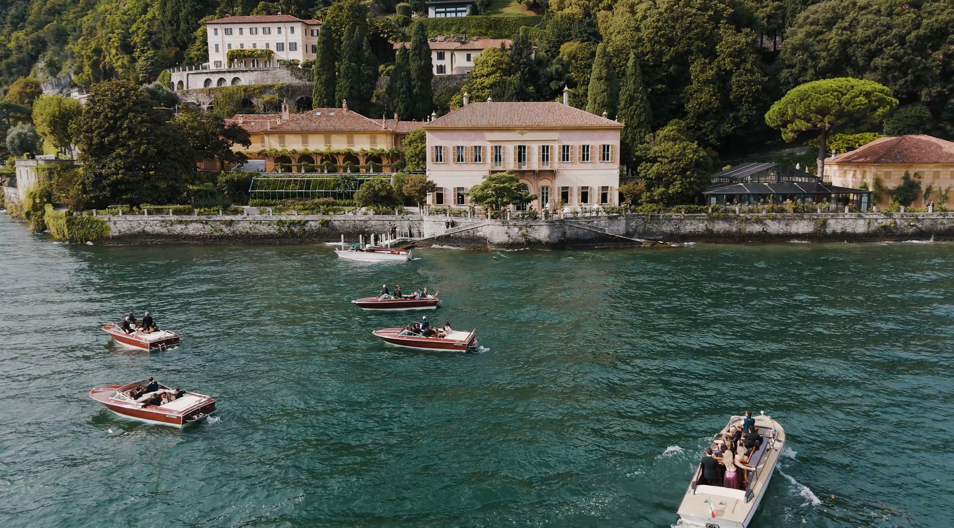 The cypress avenue along the Villa Pizzo shoreline on Lake Como, seen from the water in the afternoon