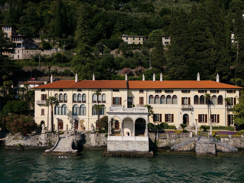 Bride and groom on a villa terrace overlooking Lake Como at golden hour