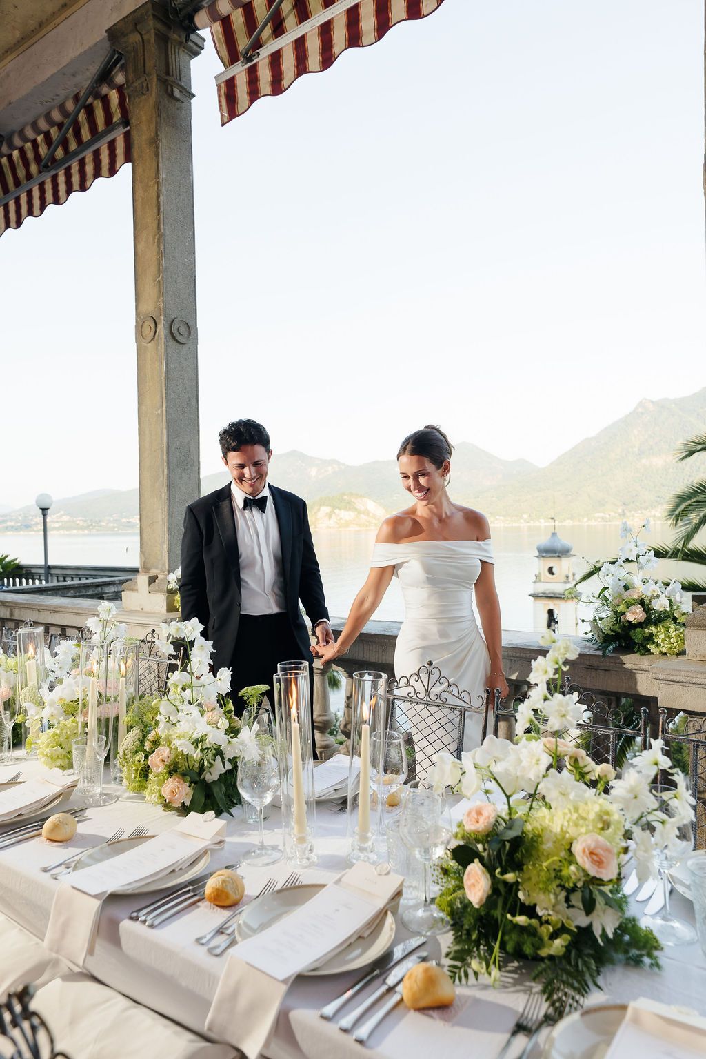 Long dinner table set for a wedding reception beside Lake Como