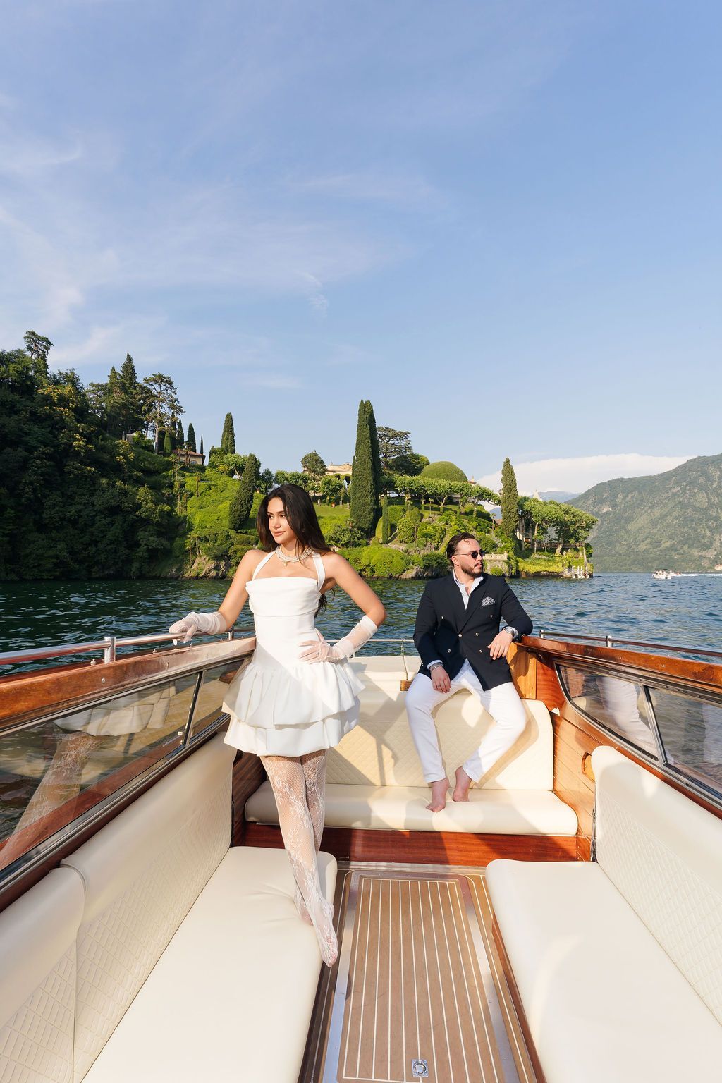 Newlyweds on a classic wooden Riva boat crossing Lake Como