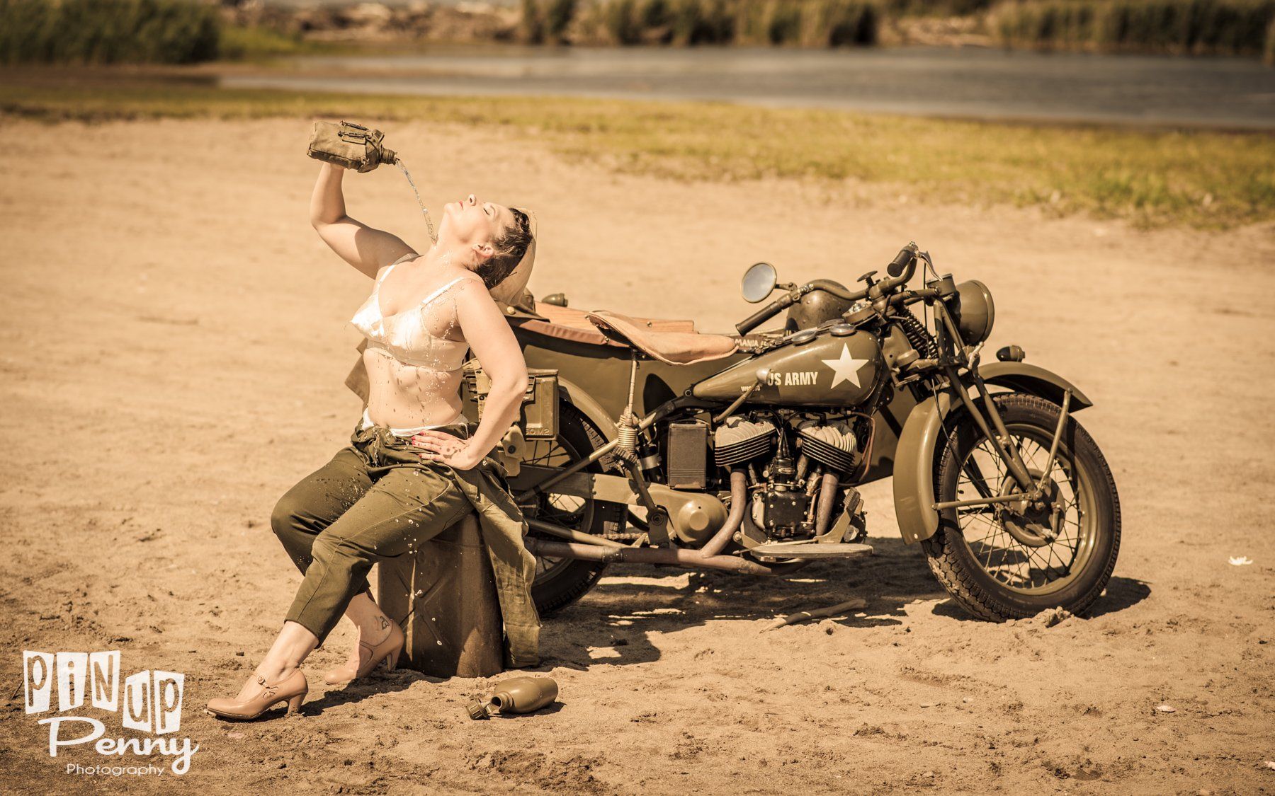 a woman is drinking from a bottle next to a motorcycle .