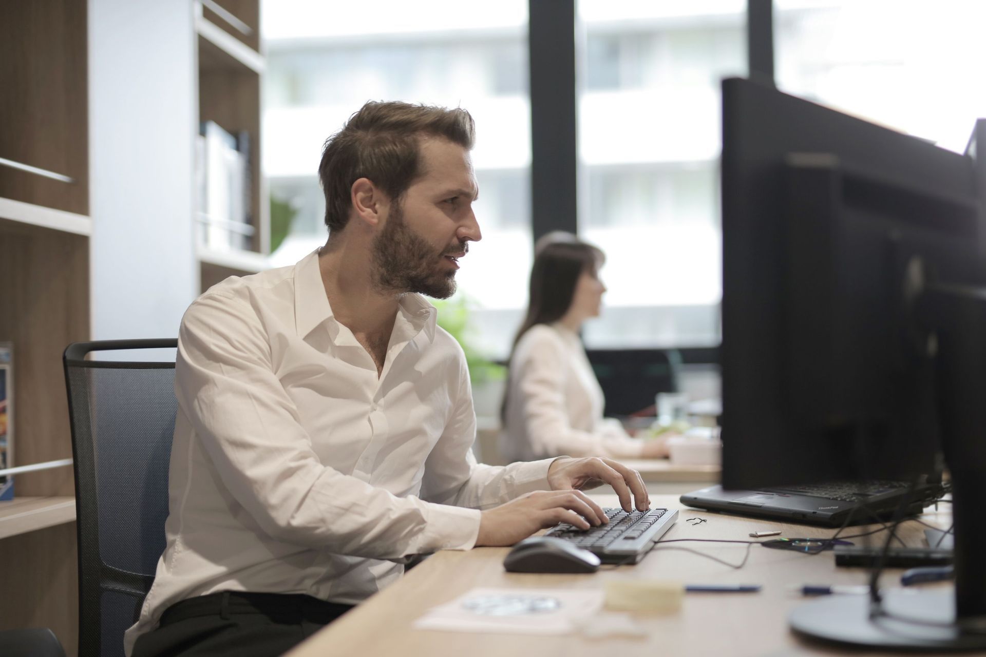 IT professional using a computer in an office, representing managed IT services.