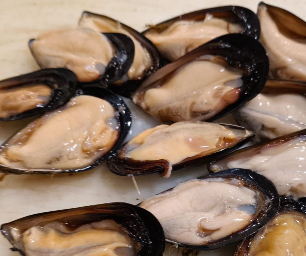 Gamberetti di un arancione brillante disposti su ghiaccio tritato in un mercato del pesce.