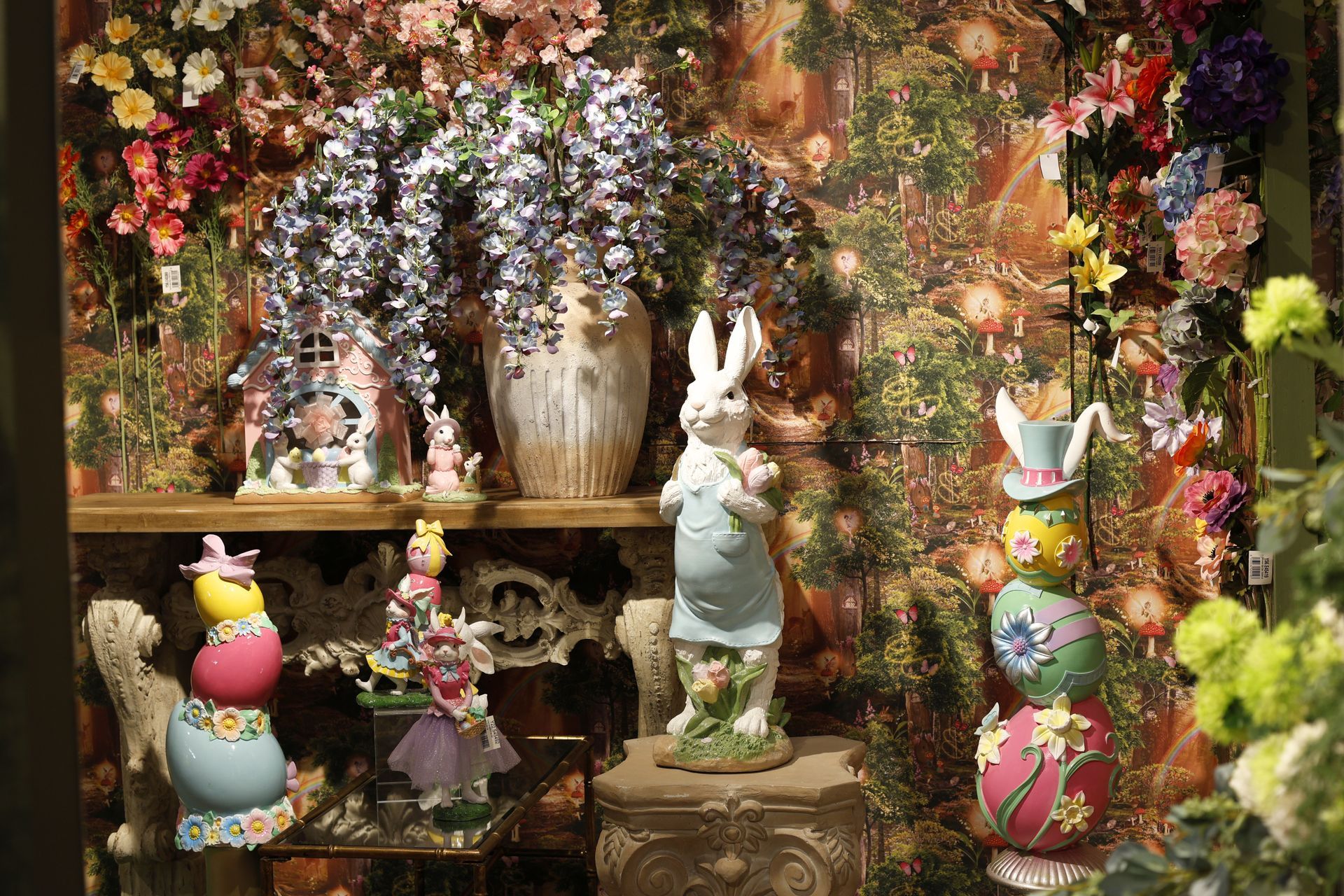 Flower-filled display with rabbit figurines and pastel Easter decorations on shelves