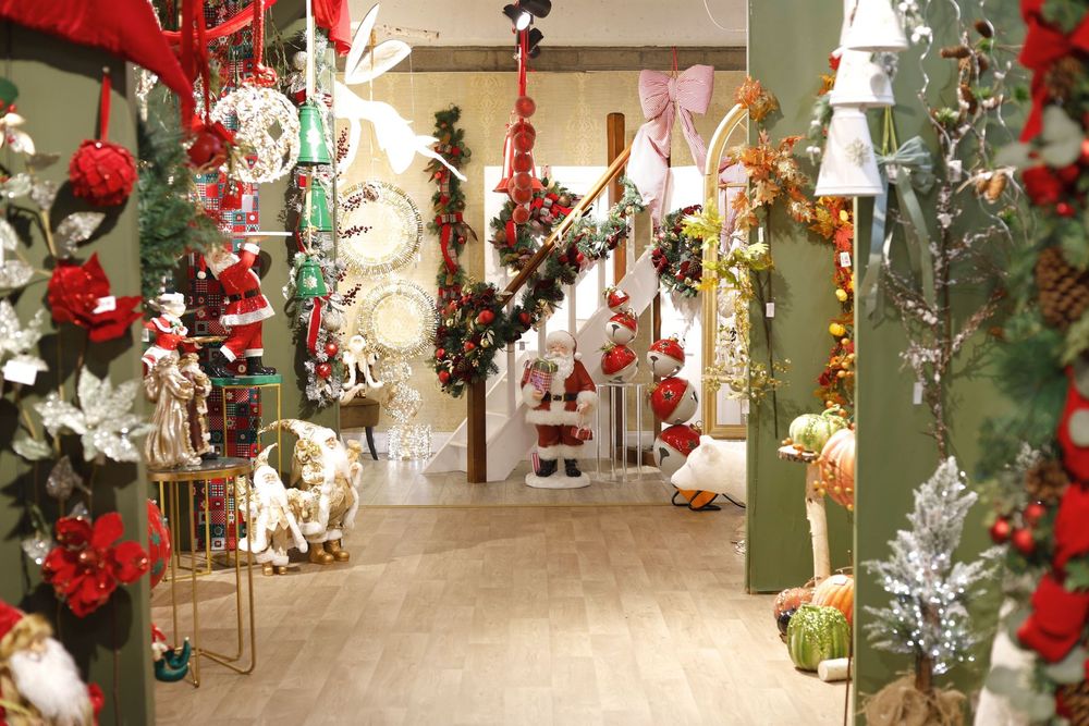 Holiday-decorated hallway with garlands, ornaments, wreaths, and Christmas trees in red, green, and white