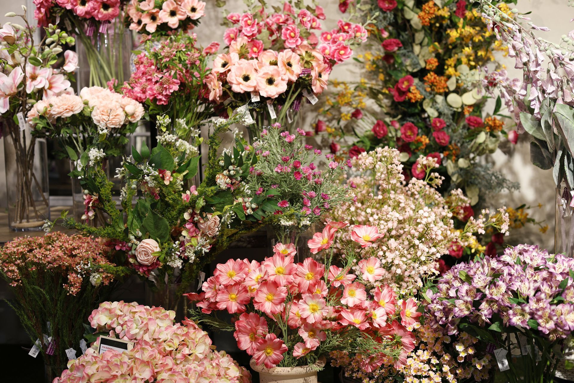 Colorful flower display with pink, white, and yellow blossoms in a lush garden arrangement