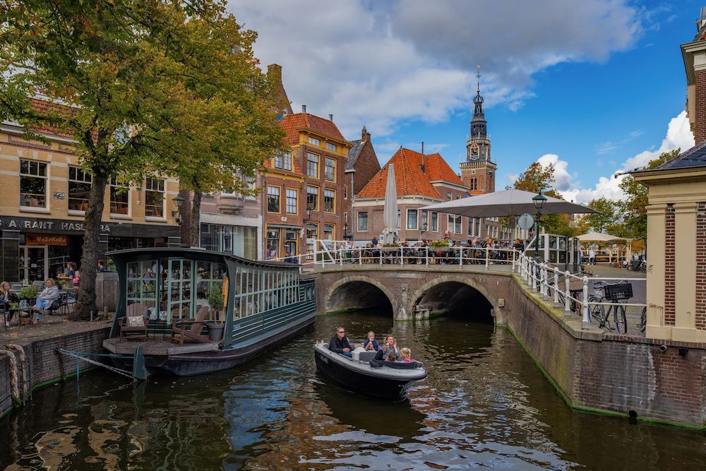 Een boot vaart door een kanaal in een stad.