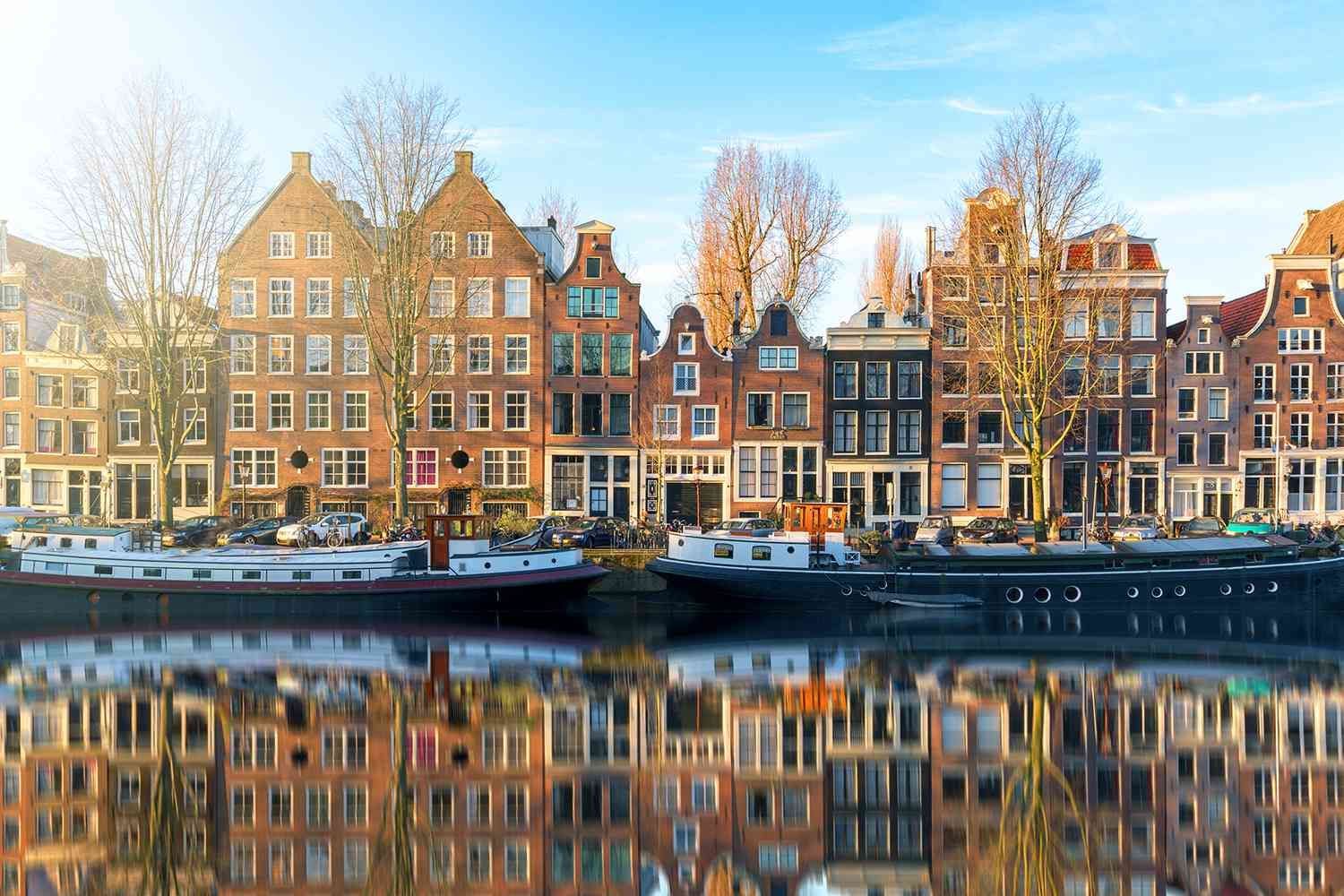 Een rij gebouwen langs een rivier met een boot in het water.