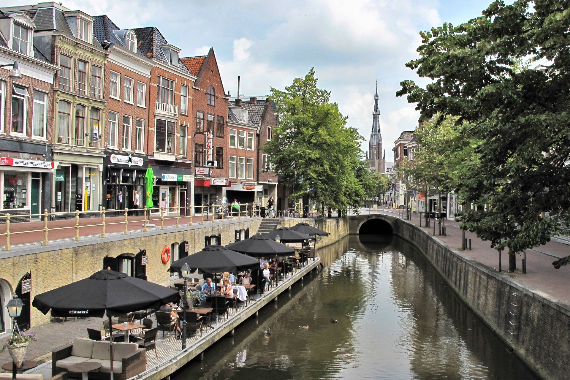 Een rivier die door een stad stroomt met tafels en parasols