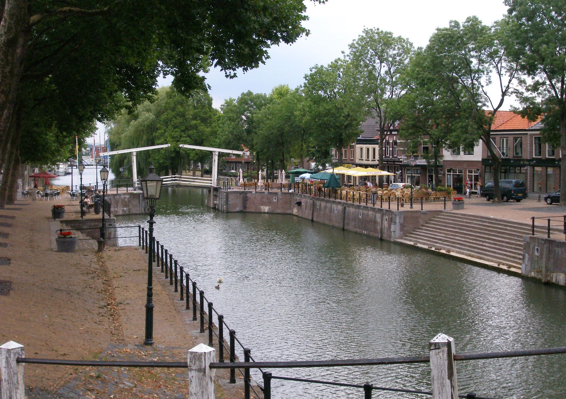 Een rivier omgeven door bomen en gebouwen in een stad