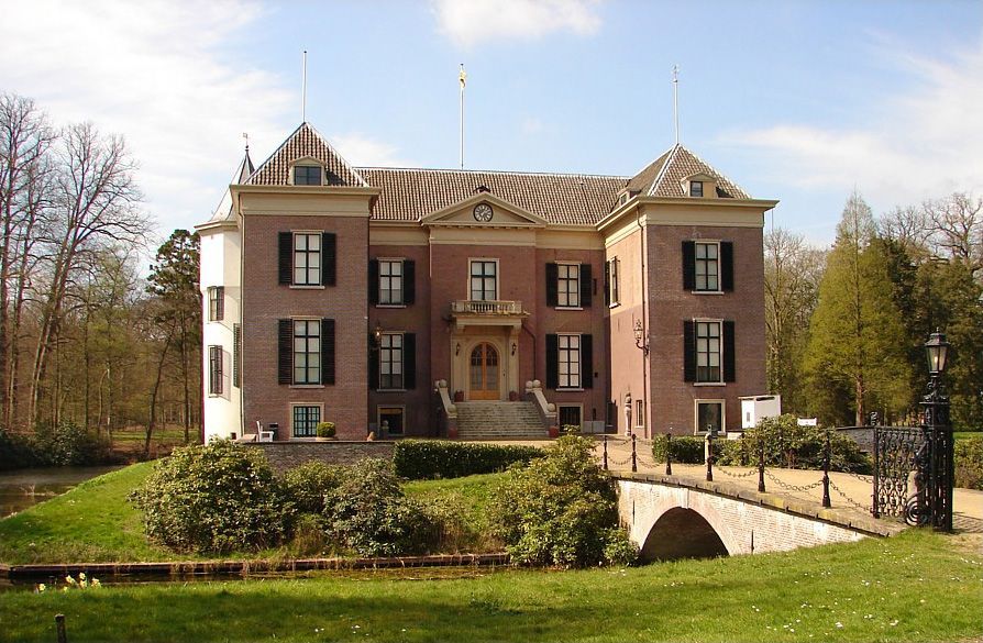 Een groot bakstenen gebouw met een brug ervoor