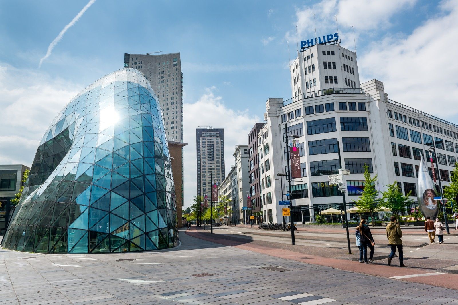 Een groep mensen loopt voor een gebouw in een stad.