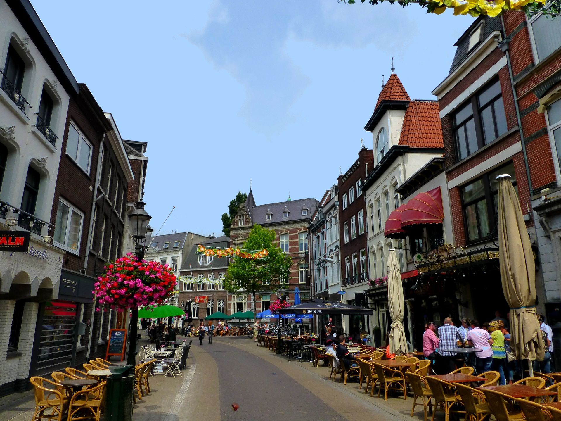 Een stadsstraat met tafels en stoelen en een bord met de tekst 'uitverkoop'