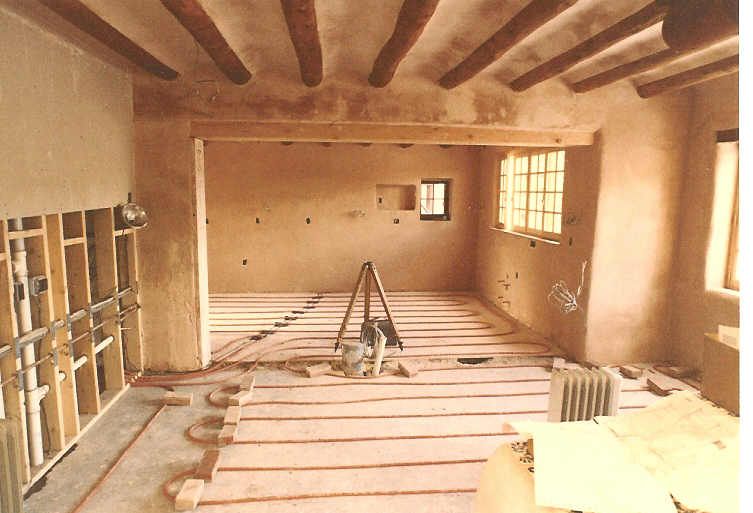 A room with wooden beams and a ladder on the floor