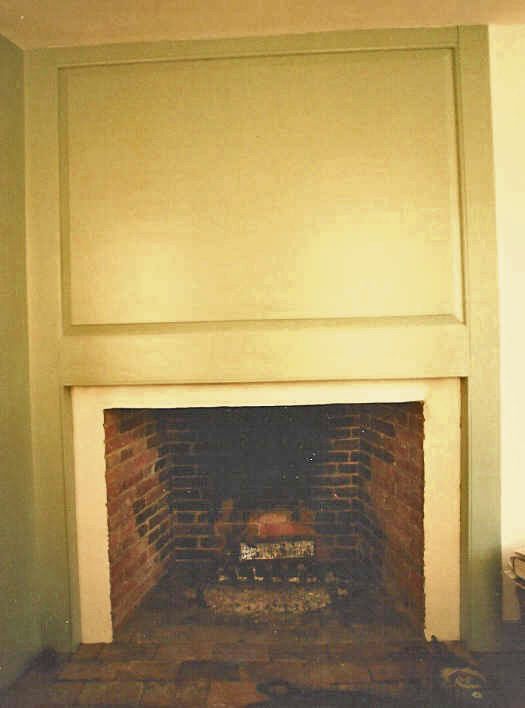 A brick fireplace with a white mantle in a living room