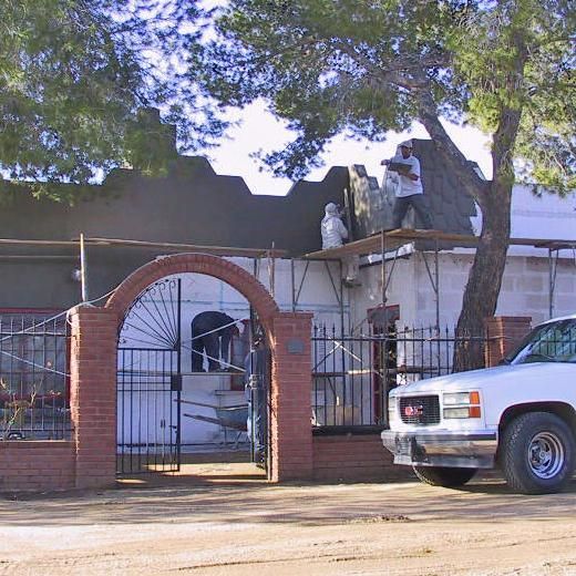 A gm truck is parked in front of a house under construction