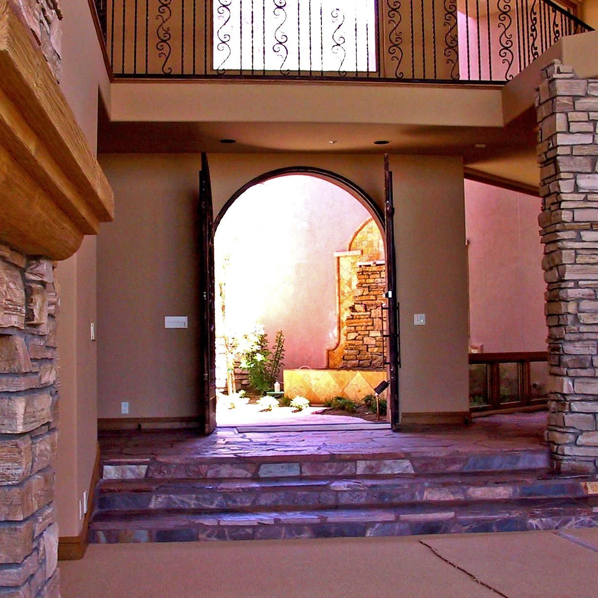 A brick archway in a house with stairs leading up to it