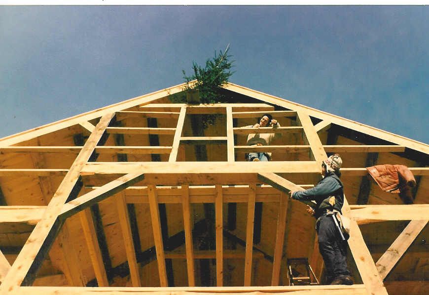 A man is standing on top of a wooden structure