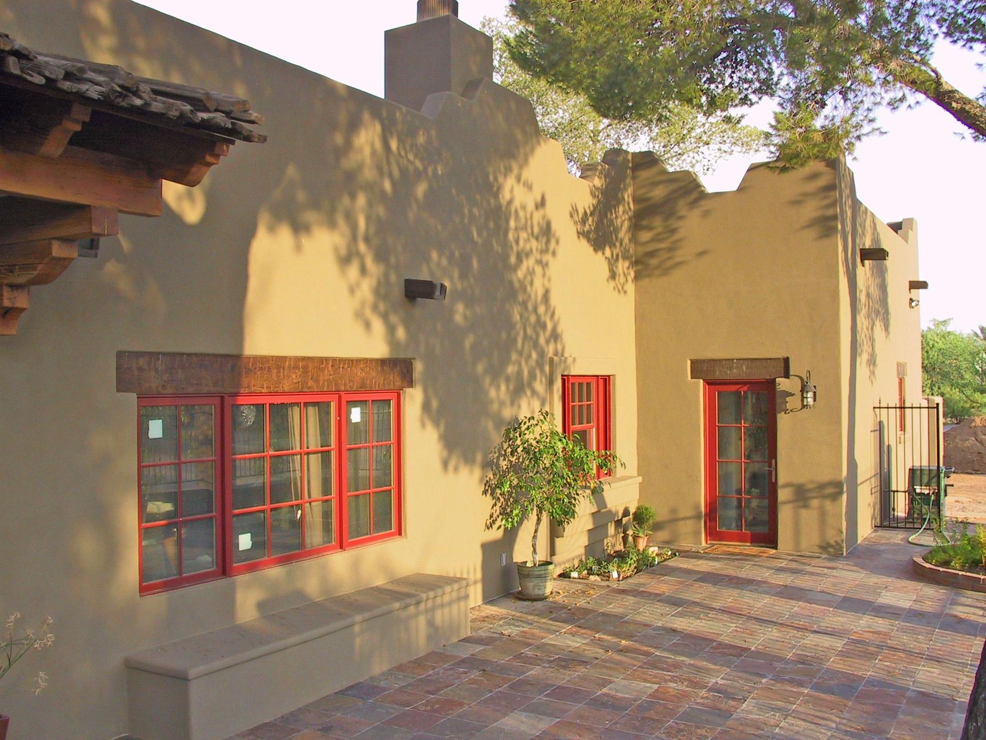 A house with red windows and a bench in front of it
