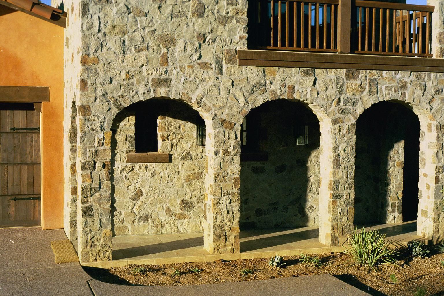 A stone building with arches and a balcony