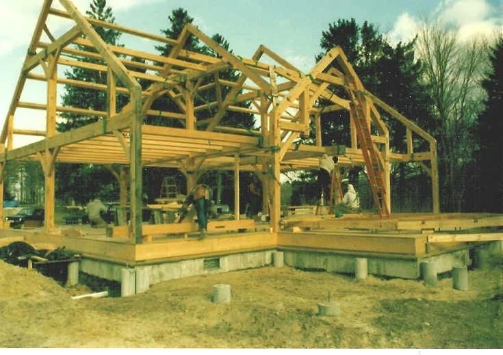 A large wooden structure is being built in a field