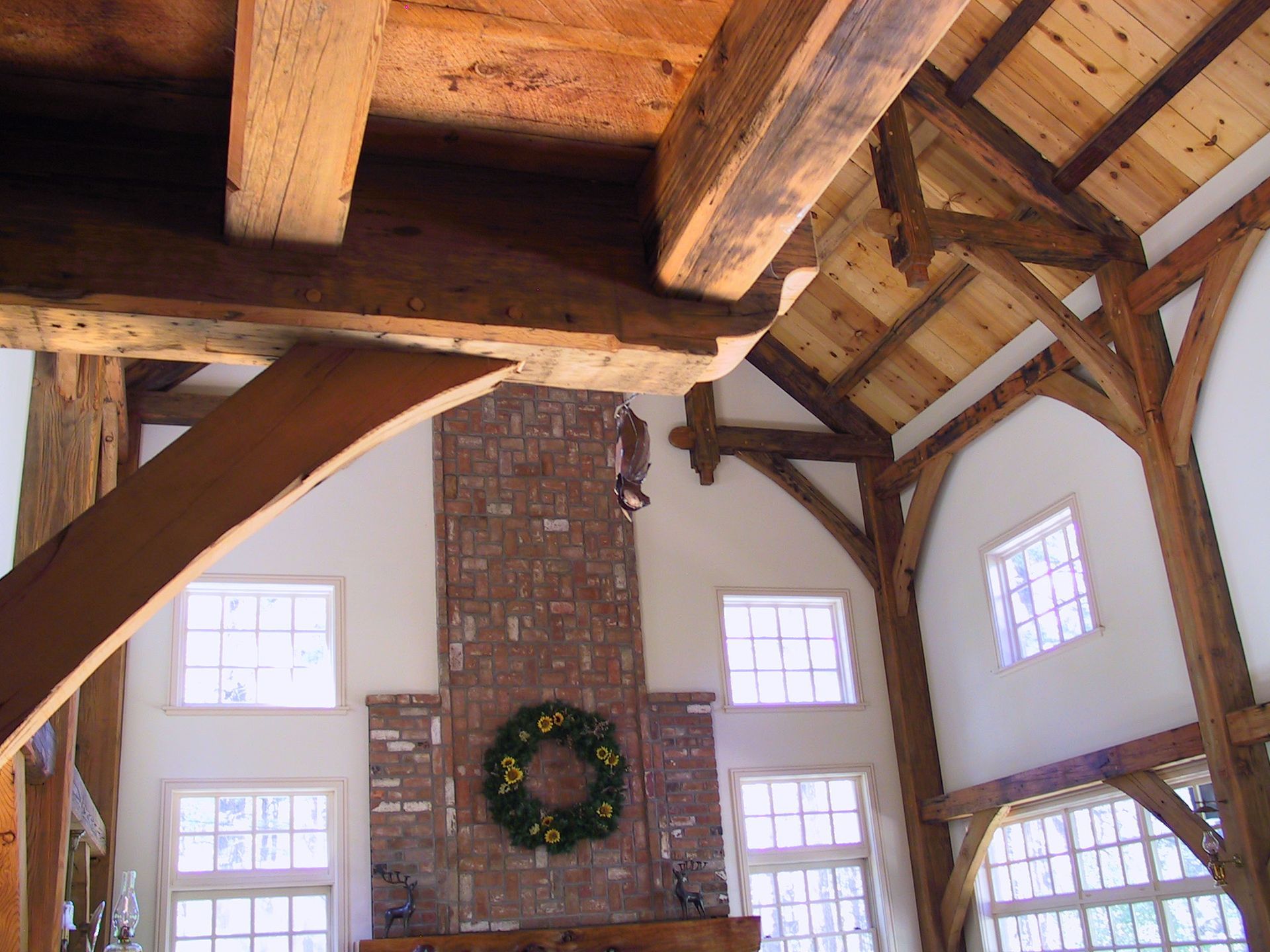 A living room with a brick fireplace and a wreath on it