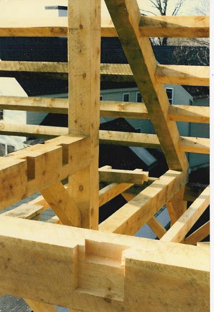 Wooden timber frame construction with intricate joinery, viewed from above.