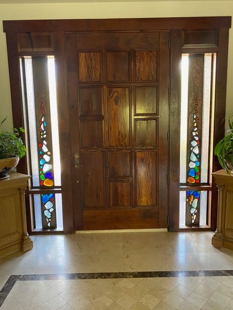 Wooden entryway door with stained glass accents and sidelights.