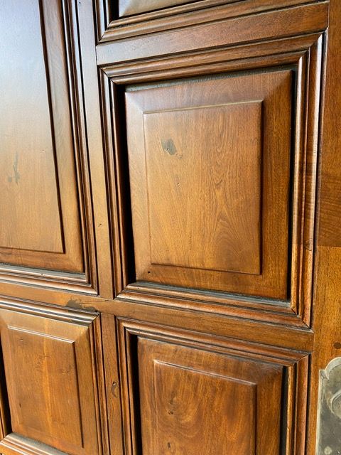 Wooden door with square panels, stained a warm brown color.