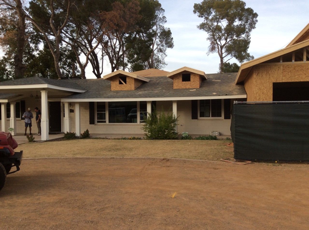 A house under construction with a black fence in front of it
