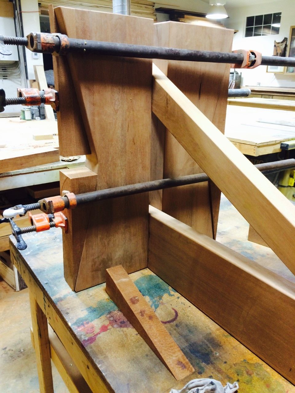 A piece of wood is being glued together with clamps
