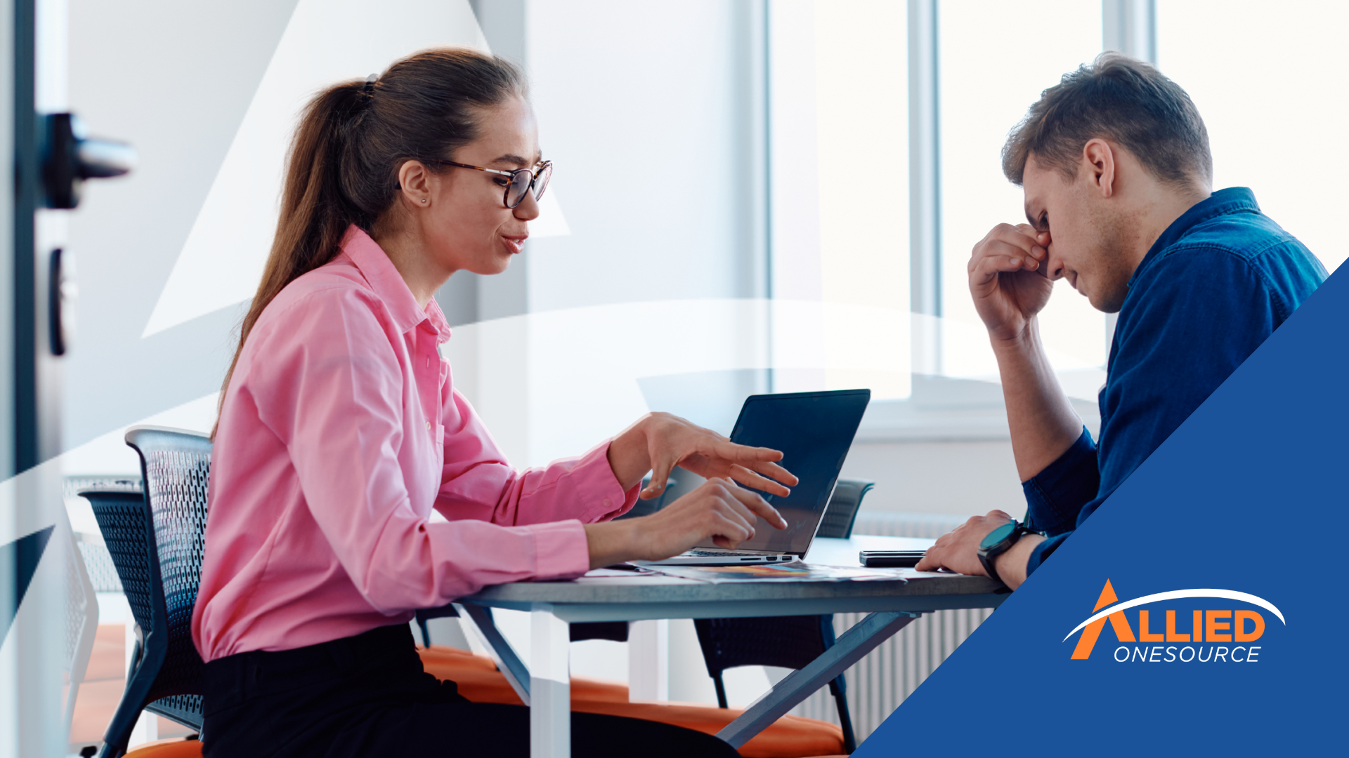 A man and a woman at a table with a laptop, demonstrating emotional intelligence in interviews and w