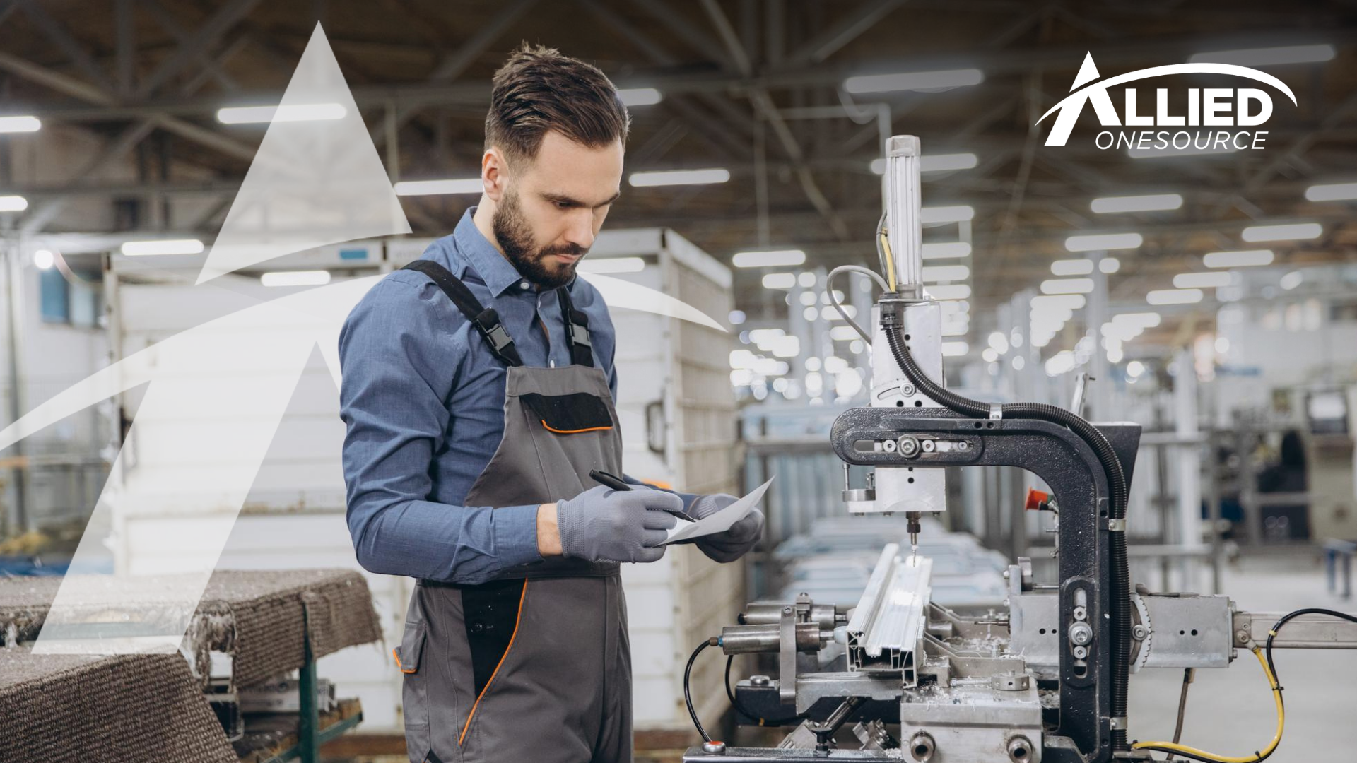 Worker inspecting paperwork at a factory, representing staffing agencies in manufacturing.