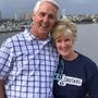 A man and woman are posing for a picture and the woman is wearing a cougars shirt